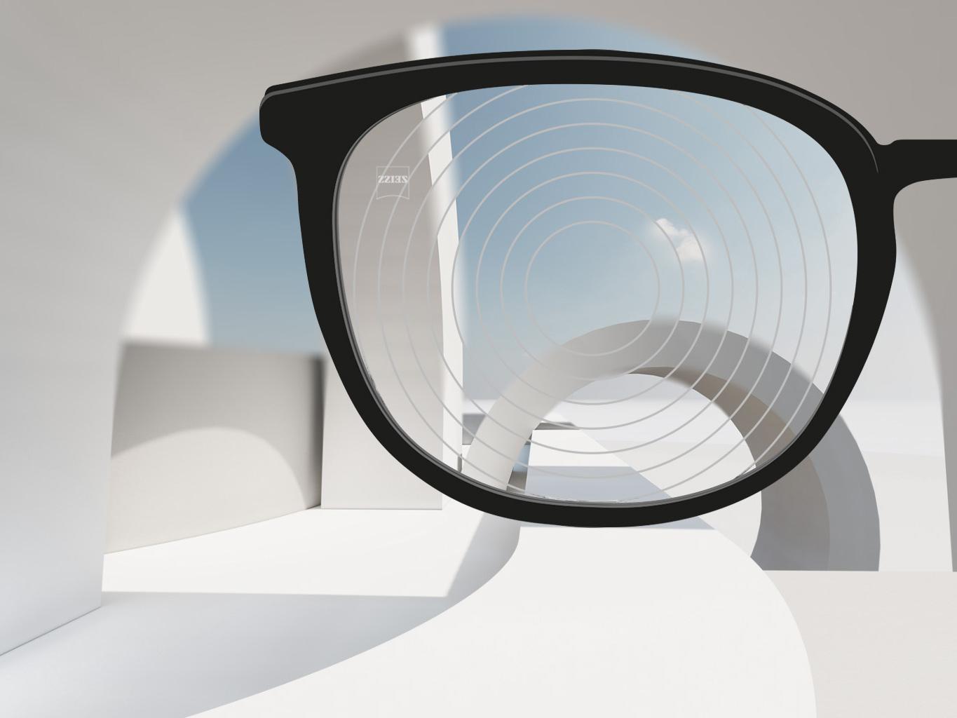 A close-up image of myopia management lenses by ZEISS, with black spectacle frames and concentric circles on the lens surface. 