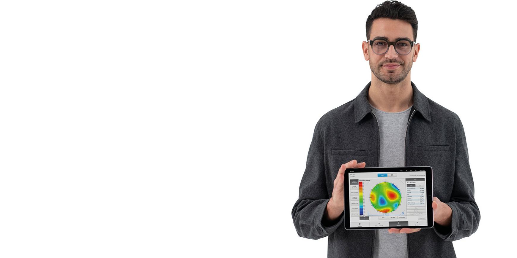 Young man wearing ZEISS lenses looking in the camera and holding an i.Pad showing pre-information for an accurate subjective refraction.