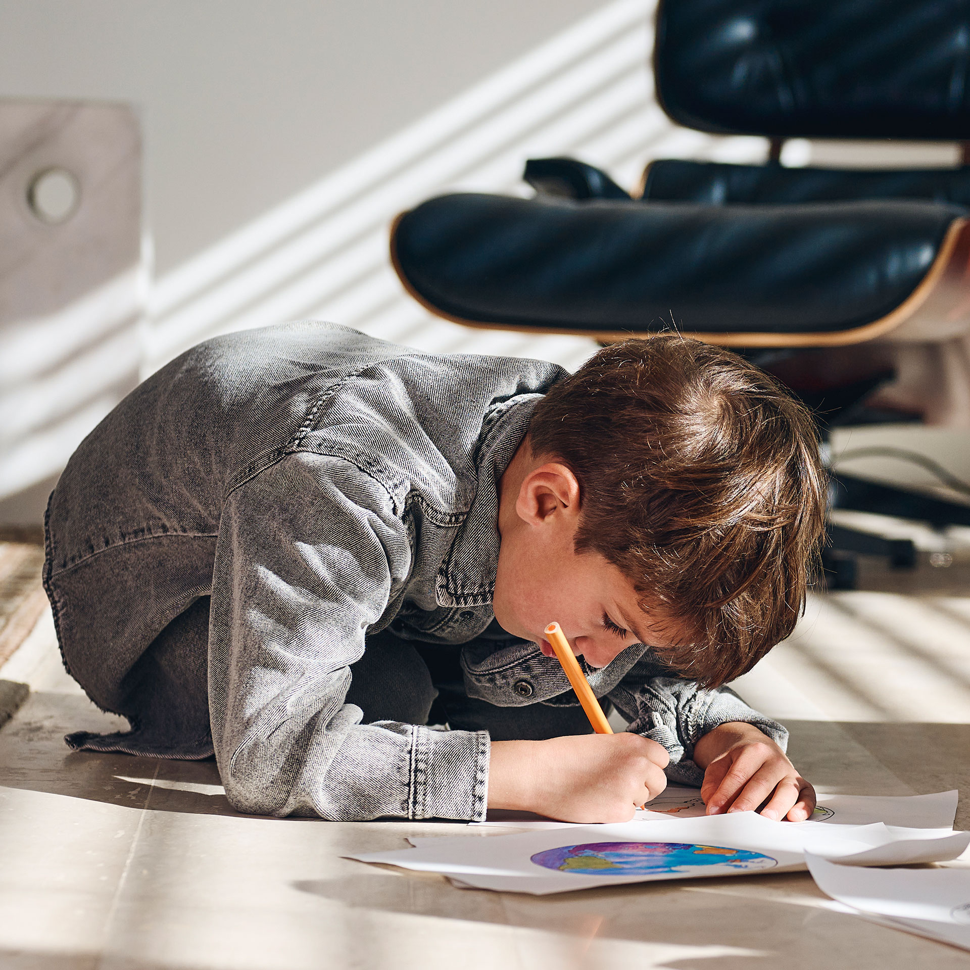 Young boy coloring very with face very close to the paper