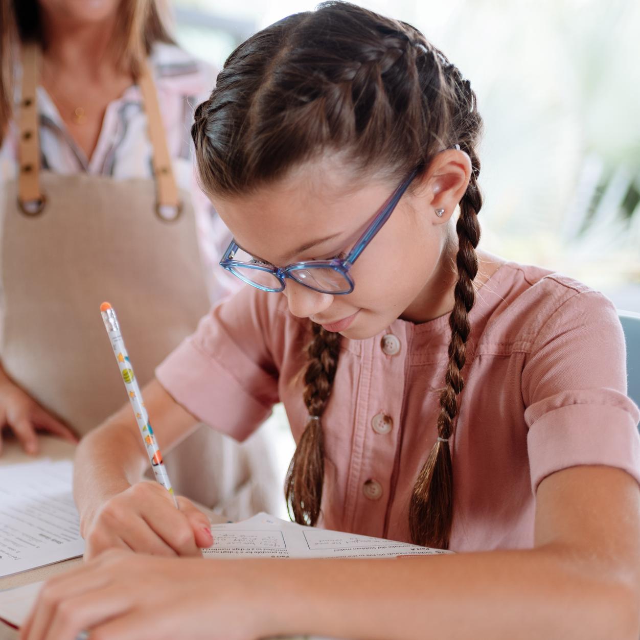 Girl with glasses writing with pen