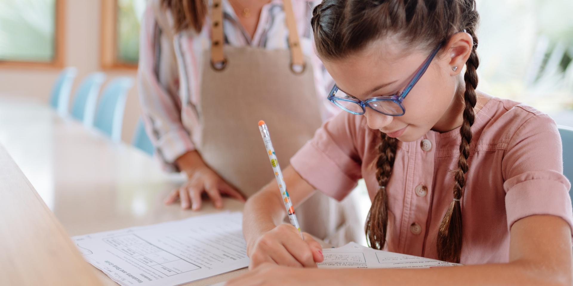 Girl with glasses writing with pen