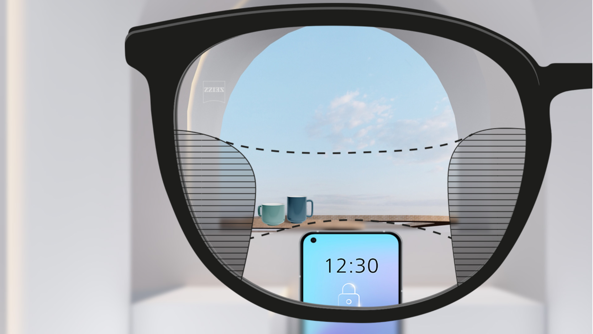 從蔡司 SmartLife 漸進鏡片看到的視野：背景有一部智能手機和杯子，鏡片完全清晰，但左右兩側均有細長模糊區域。