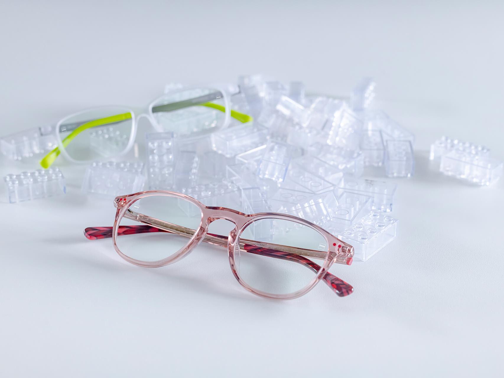兩副配備蔡司鏡片和 DuraVision® Kids 鍍膜的兒童眼鏡。眼鏡放在透明的兒童積木之間。