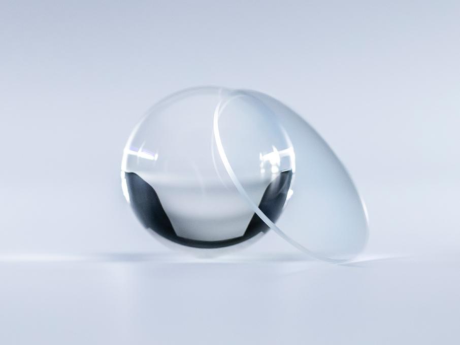與旁邊的玻璃球相比，具有蔡司 Platinum 鍍膜的鏡片晶瑩剔透，沒有反光。
