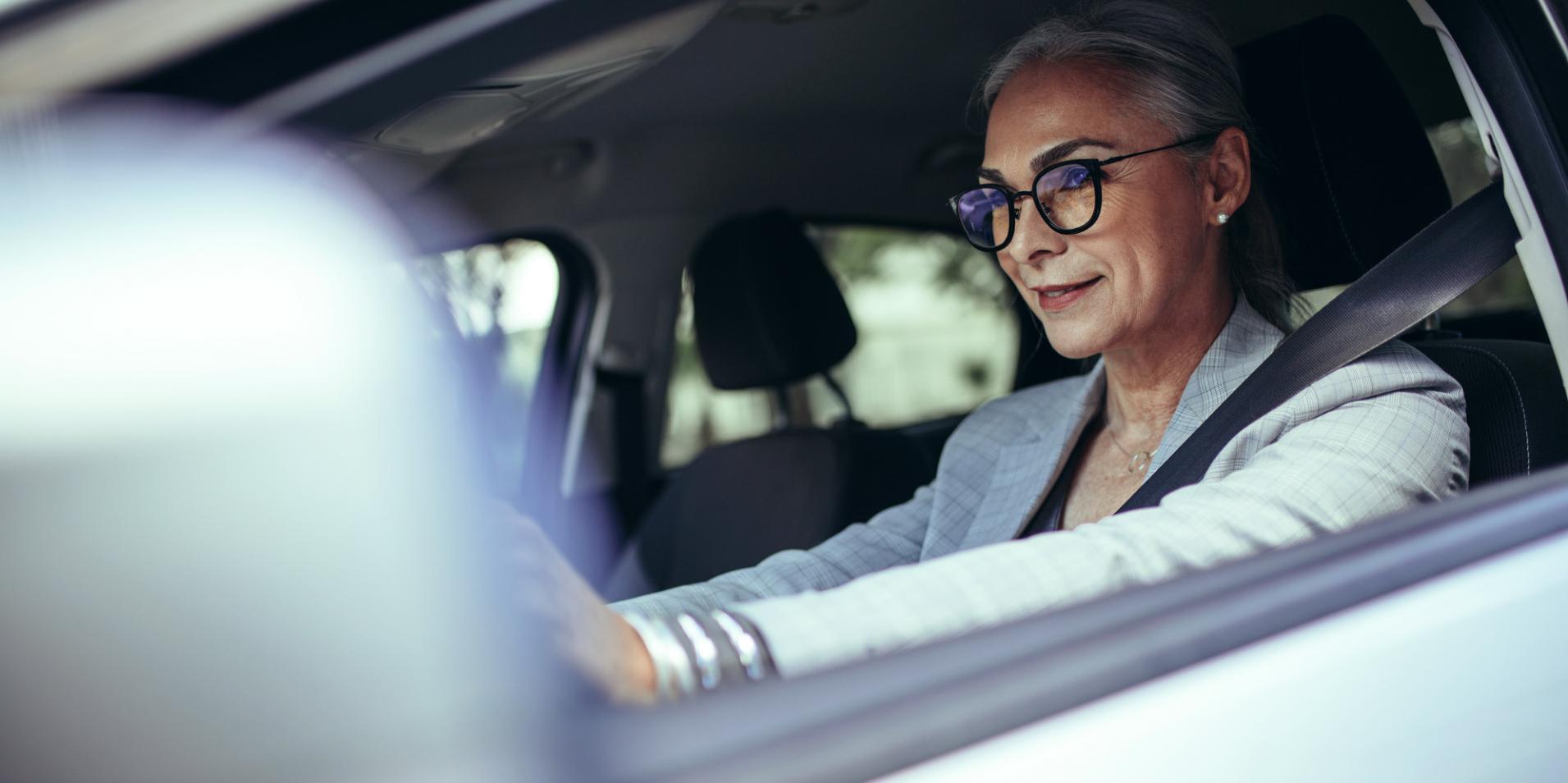 車內一位成熟女士戴著蔡司 DriveSafe 眼鏡。