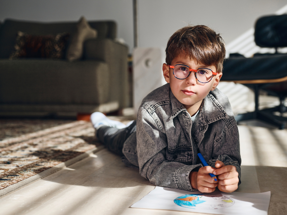 A young boy wearing ZEISS MyoCare lenses looks straight into the camera.