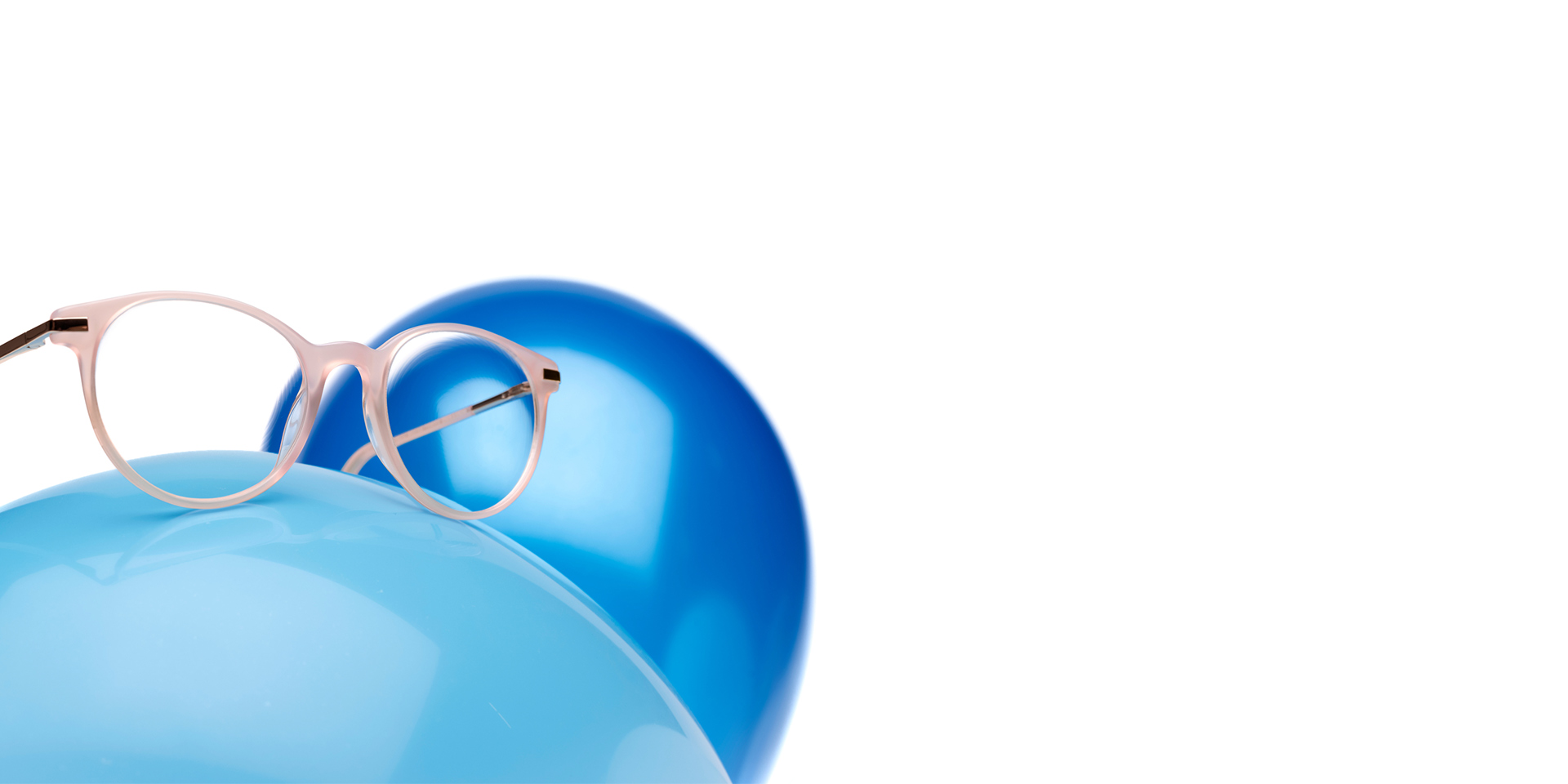 使用蔡司MyoCare鏡片的米色玫瑰眼鏡架，在淺藍色氣球上顯示。背景是顏色稍微深一點的藍色氣球。
