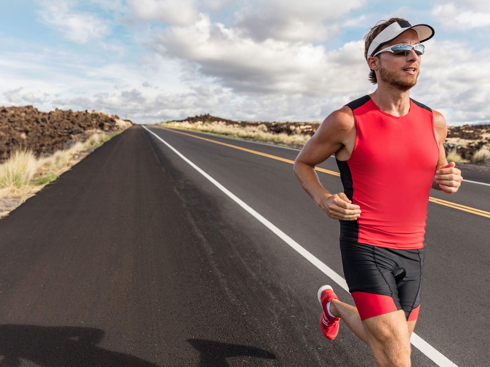 一個男人在路上奔跑時穿著運動服和戴著運動鏡片的圖像。 